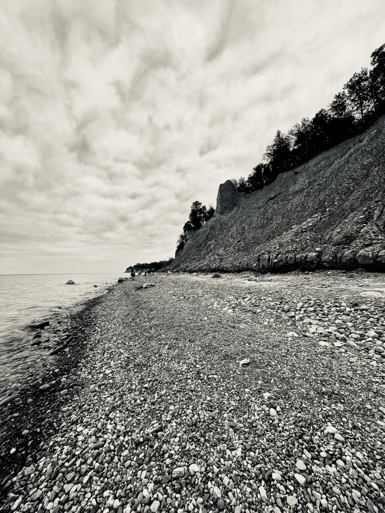 black and white photo on the beach at Chimney Bluff State Park with clouds in sky